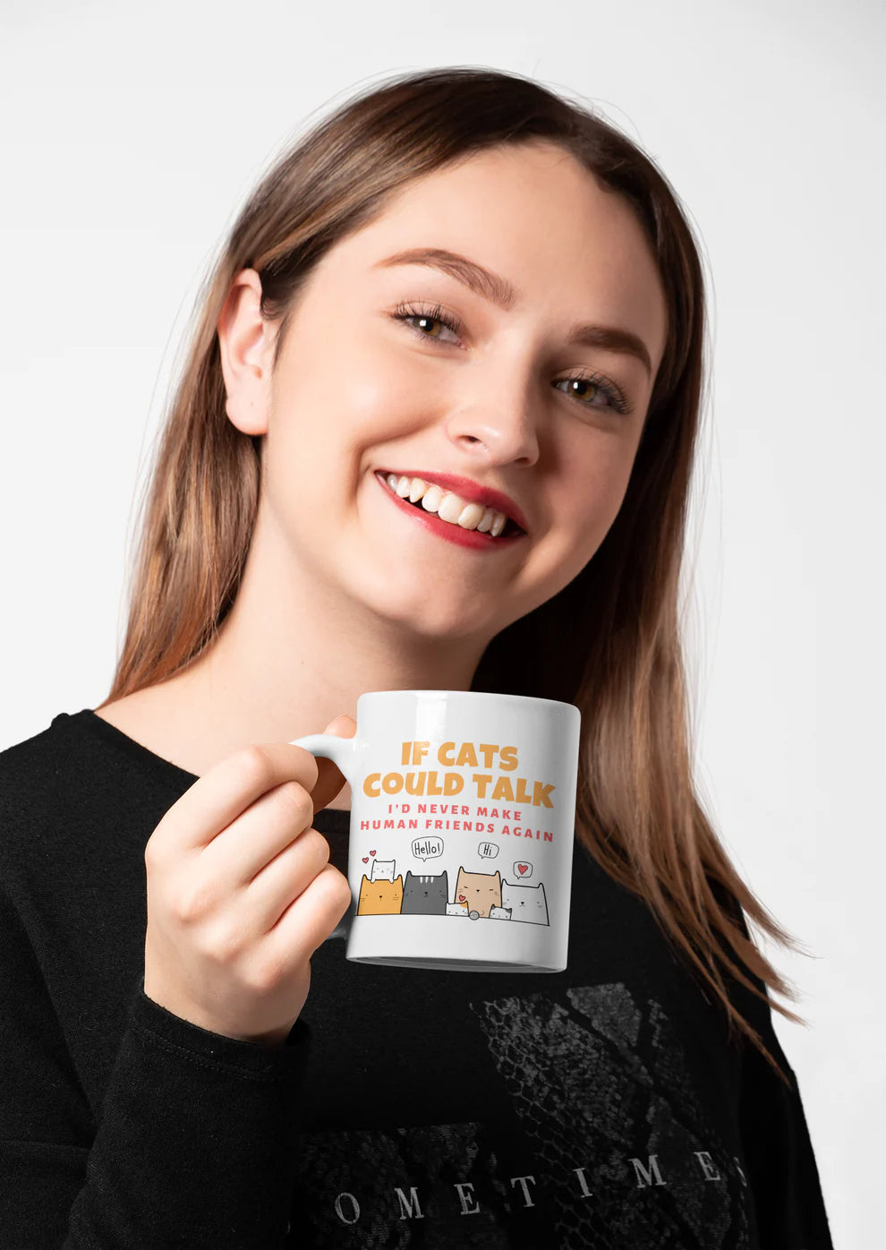 Woman holding a mug with a humorous cat-themed design against a plain background