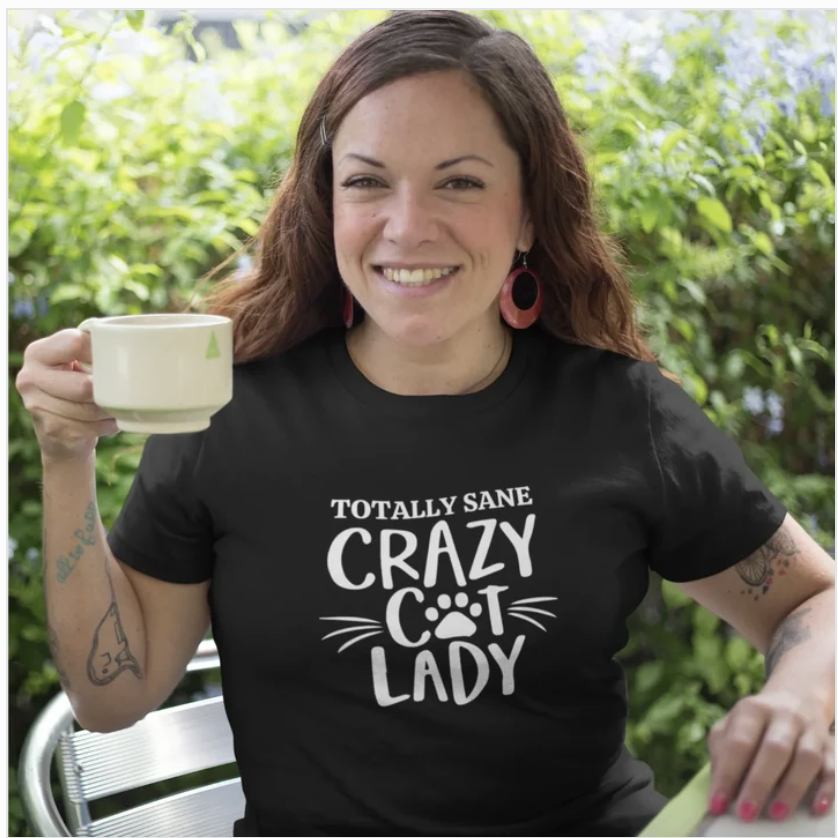 Smiling woman holding a cup of tea in a black Totally Sane Crazy Cat Lady t-shirt