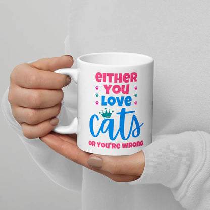 Hand holding a white mug with colorful text on a gray background