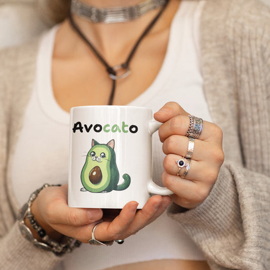 Person holding a white mug with an avocado-themed design and text.