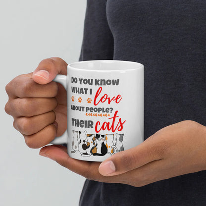 Person holding a white mug with cat-themed text and illustrations.