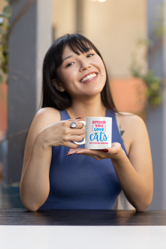 Woman holding a mug with a cat-themed design in an indoor setting