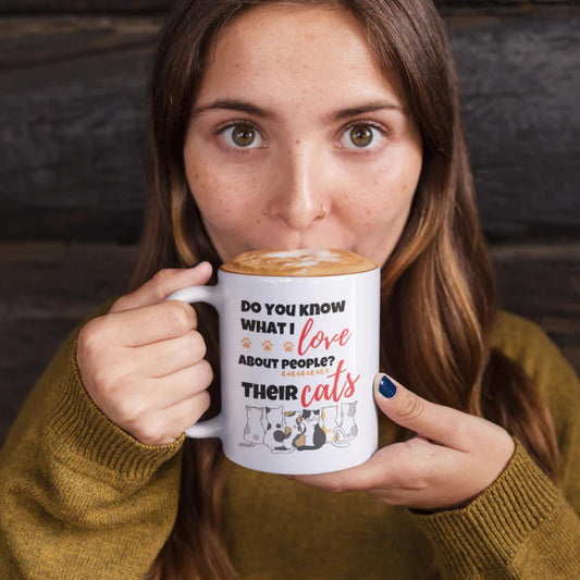 Woman holding a mug with a humorous text design, wearing a mustard yellow sweater.